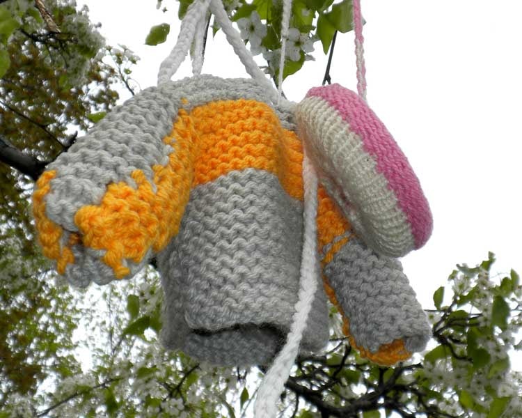 A knitted jacket and strawberry frosted donut — the donut that started it all — hanging together