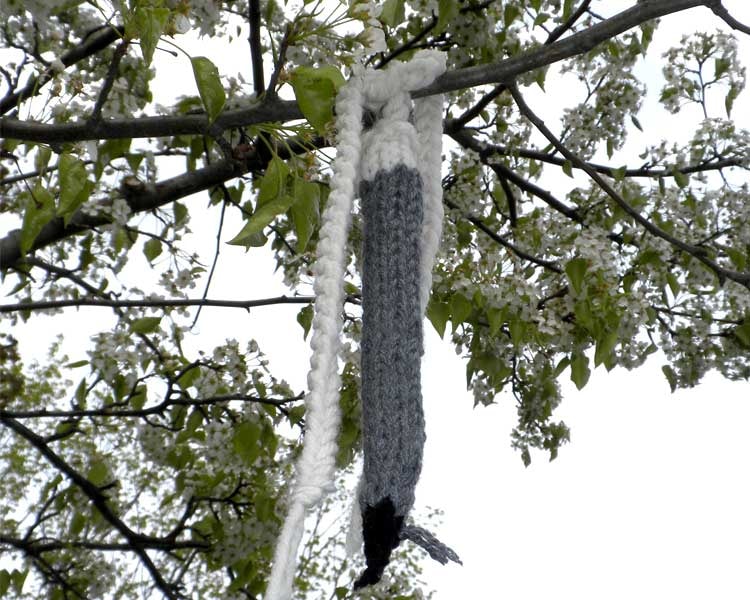 A knitted mechanical pencil hanging from a blossoming branch