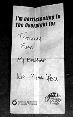 Luminary bag reading "Tommy Fuss — My Brother — We Miss You"